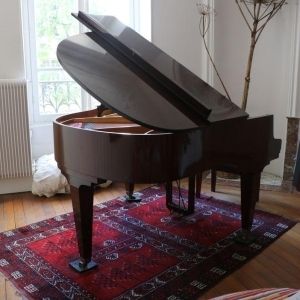 Schimmel Piano à queue modèle 147 en finition acajou brillant.